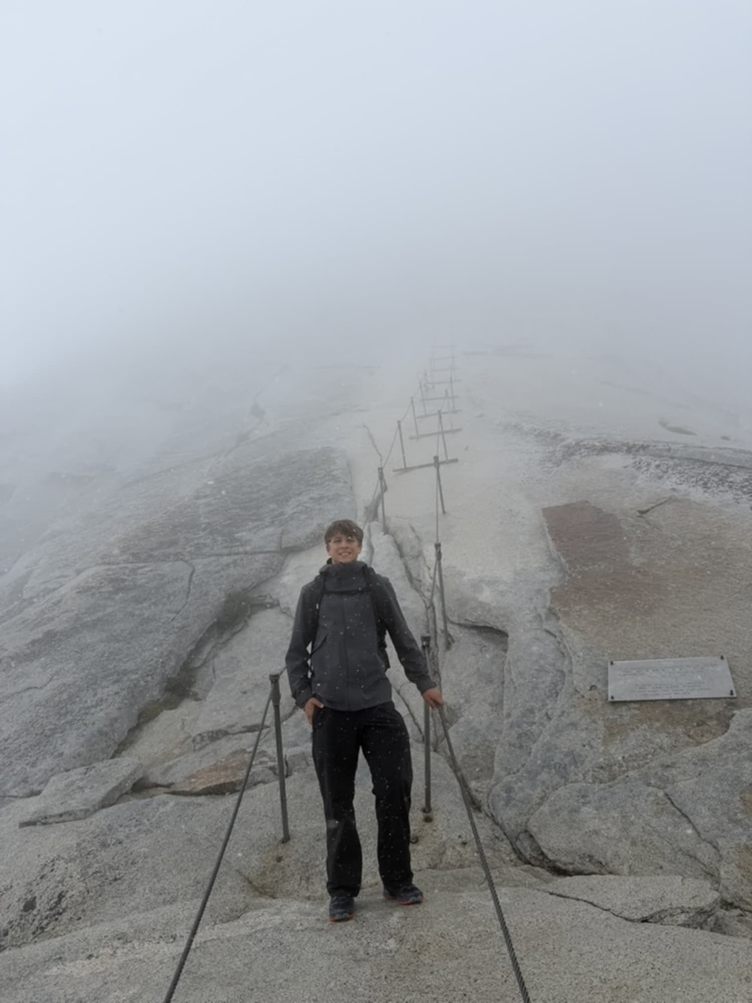 Hayden at the top of the Half Dome cables in fog and blowing sleet, Yosemite